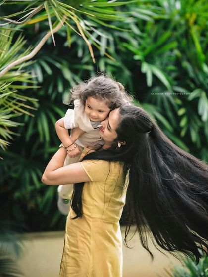 This mother-daughter portrait is full of movement and life. The mother's long hair flowing in the wind as she holds her child creates a stunning and artistic image that feels both candid and timeless.