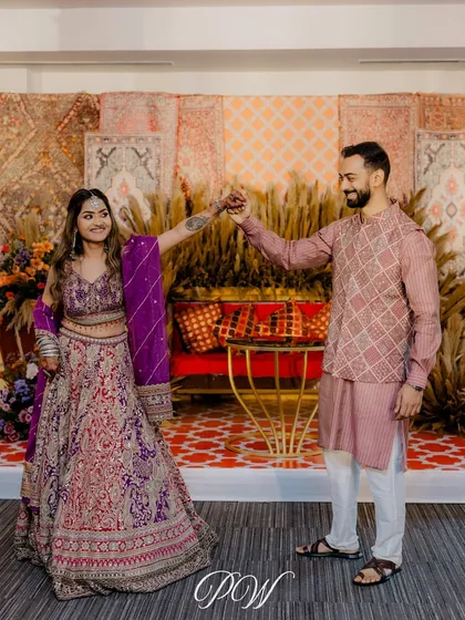 A couple enjoying their Boho-themed Mehendi. The backdrop of rustic carpets and pampas grass creates a relaxed, chic, and free-spirited vibe.