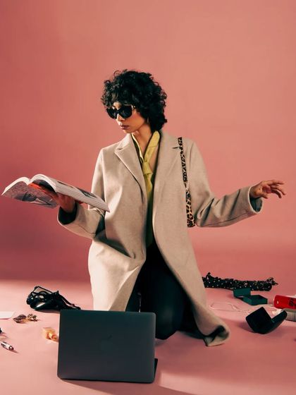 The opening shot for the 'Hot Mess' editorial, showing a fashion professional amidst organized chaos. It's a narrative about life after work.