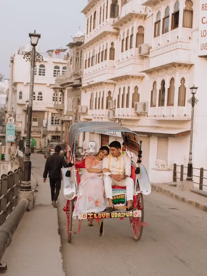 A charming shot of the couple enjoying a rickshaw ride through the historic streets of Udaipur, capturing the authentic and vibrant atmosphere of the city.