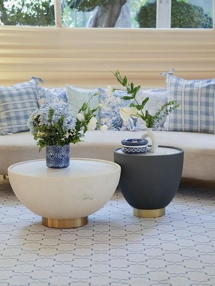 A chic lounge area with a beige sofa and custom-printed blue and white pillows.