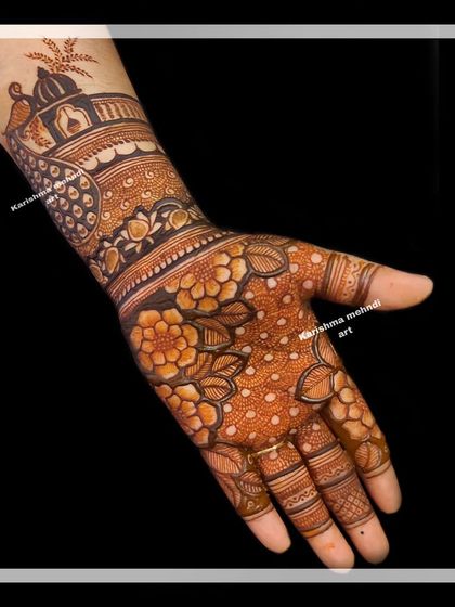 This design combines floral and traditional elements on the back of the hand. It features a peacock and palace motif on the wrist, with the palm filled with a dense floral pattern.