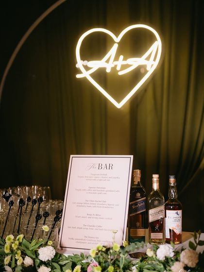 A close-up of the custom neon sign and the elegant bar menu.