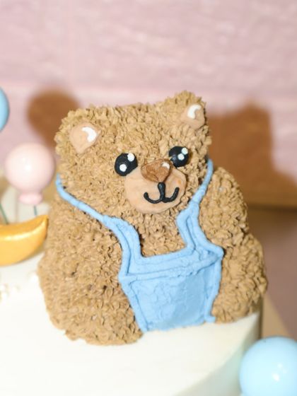 A close-up of the hand-piped teddy bear on our "We Can Bearly Wait" baby shower cake. The textured buttercream gives it a cuddly, plush look.