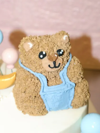 A close-up of the hand-piped teddy bear on our "We Can Bearly Wait" baby shower cake. The textured buttercream gives it a cuddly, plush look.