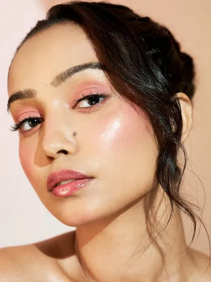A beautiful portrait showcasing healthy, glowing skin. The lips are kept glossy and the eyes soft to keep the focus on the radiant complexion.