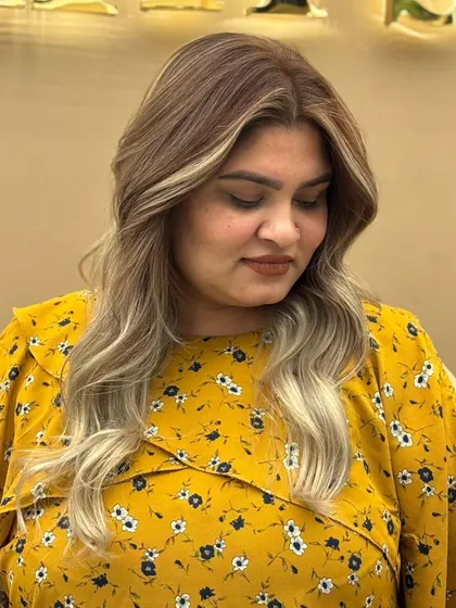 A happy client showing off her new balayage hair color. The lighter pieces frame her face and give her a radiant glow.