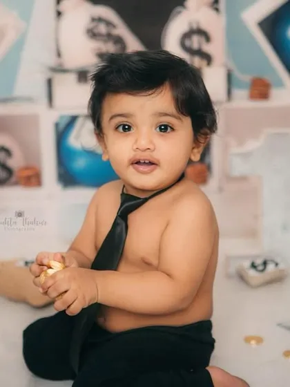 This little businessman is counting his gold coins. The Boss Baby theme is a super fun and popular choice for first birthday photoshoots.