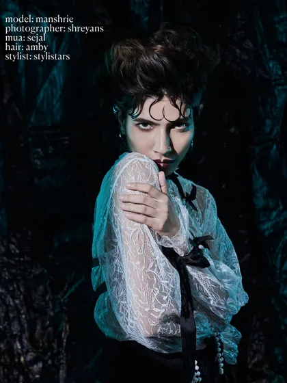 A moody, cinematic portrait with cool-toned lighting, highlighting the texture of the lace blouse and the model's sharp, confrontational expression.