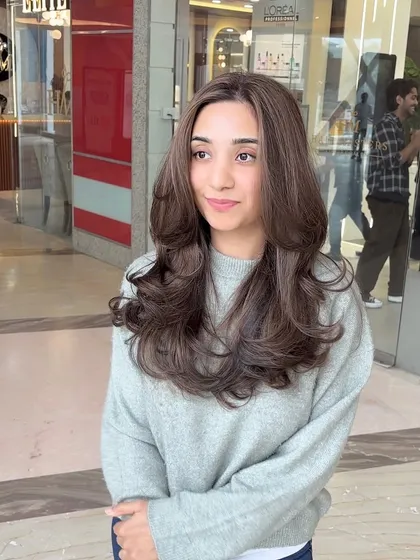 A perfect example of a complete hair transformation without bleach. The color is a cool, muted brown that looks incredibly sophisticated, and the hair is styled with volume and bounce.