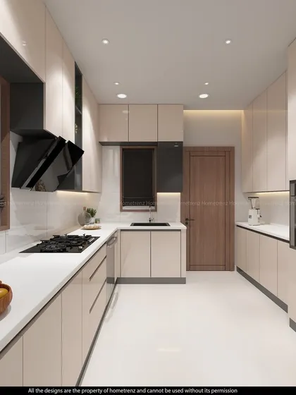 A beautiful and functional kitchen with cream-colored glossy cabinets, a black chimney, and built-in ovens.