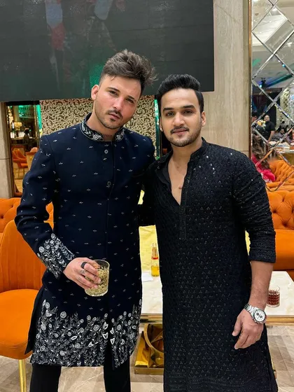 Two friends in our custom designs. On the left, the navy blue Indo-Western, and on the right, a black embroidered kurta.