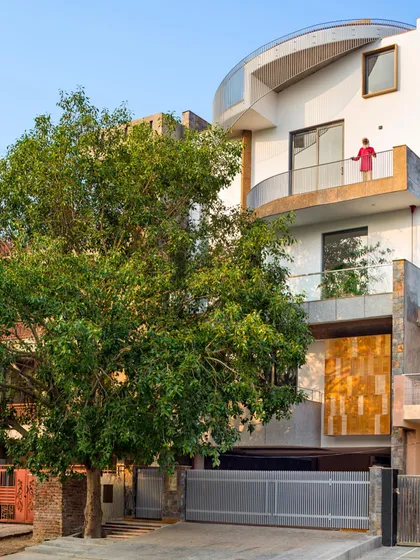 The exterior of the People Tree House, named 'Ashvattha', is designed in deference to the magnificent sacred fig tree that anchors the site. The architecture embraces the tree, making it the focal point and creating a sustainable residence where nature is not just outside, but a fundamental part of the home itself.