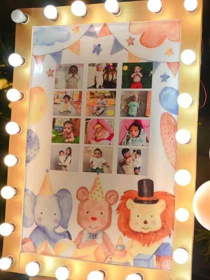 Another look at the milestone photo board for Vihaan, framed with bright marquee lights to fit the carnival theme. It becomes a beautiful focal point for guests.