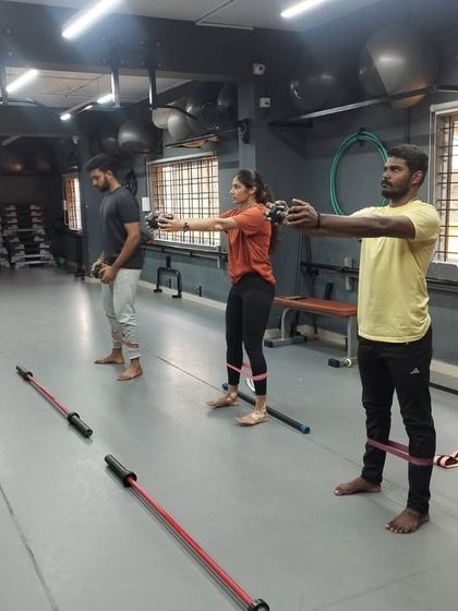 Students engage in a group exercise using resistance bands, learning how to incorporate different tools to target specific muscle groups.