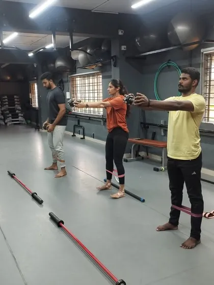 Students engage in a group exercise using resistance bands, learning how to incorporate different tools to target specific muscle groups.