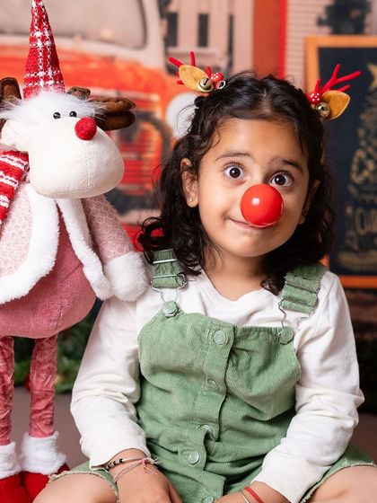 A little girl channeling her inner Rudolph. The playful props help bring out the fun and silly side of kids during the shoot.