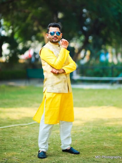 The groom strikes a pose during his Haldi ceremony. The outdoor setting and his vibrant outfit make for great photos.