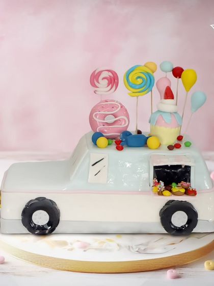 A candy truck of dreams for a sweet celebration. This car-shaped cake is loaded with lollipops, donuts, and other candies, making it a toddler's fantasy come true.