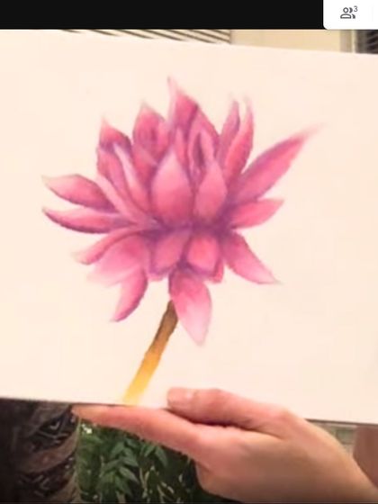 A student proudly shows her completed watercolor flower during an online class. Seeing these moments of achievement is the best part of what we do.