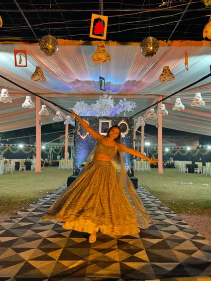 A joyful pose on the geometric-patterned dance floor of the Sangeet venue.