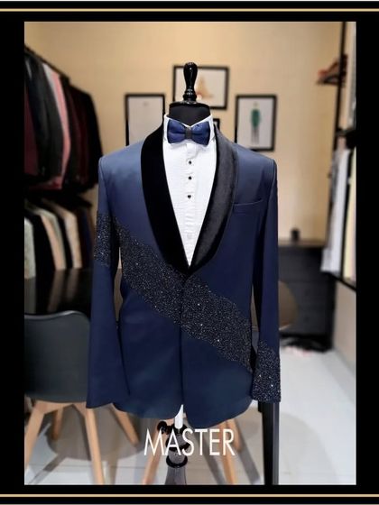 Another angle of the heavily embroidered navy blue tuxedo, showcasing the detail on the shawl collar and cuffs. This is for the man who isn't afraid to shine.
