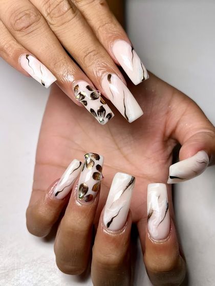 Florals with a modern metallic twist. This unique design combines a white marble base with gold leopard print and black swirl accents.