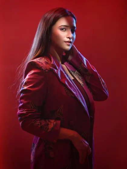 This shot captures a more pensive moment. The pose and the soft, diffused red light work together to create a portrait that feels both fashionable and narrative, as if caught in a moment of thought.