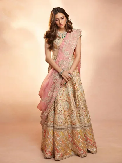 This Anamika Khanna lehenga in soft pastel tones with a pop of pink is pure elegance. It’s a sophisticated choice for a daytime wedding or a formal pre-wedding event.