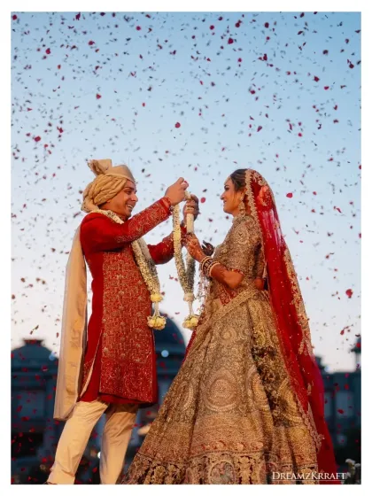 A classic Varmala moment, with petals filling the sky against a backdrop of regal domes. My focus is on capturing the pure emotion between the couple during this key ritual.