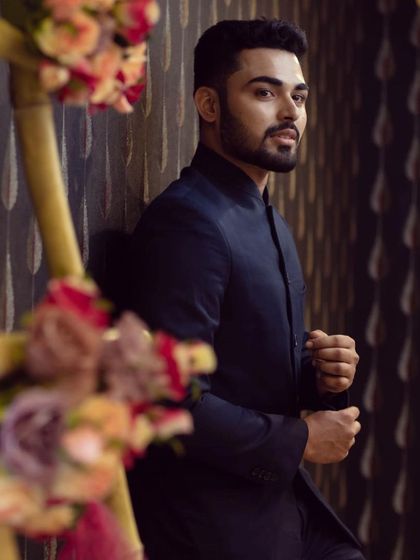 A happy client looking sharp in a classic navy blue bandhgala suit, perfect for a formal reception or engagement party.