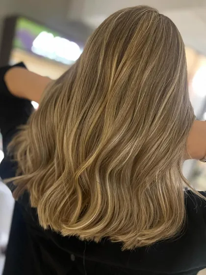 This beautiful caramel blonde look was achieved with back-to-back foils. This technique allows for a heavy concentration of highlights, resulting in a bright, blended blonde.