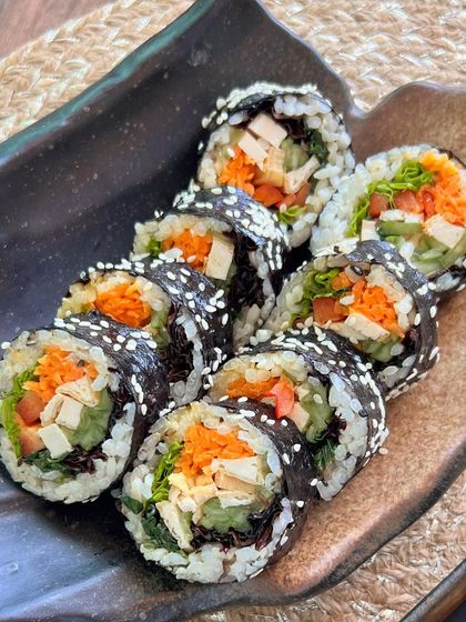 A platter of freshly made Korean Gimbap, showcasing the colorful ingredients and neat presentation.