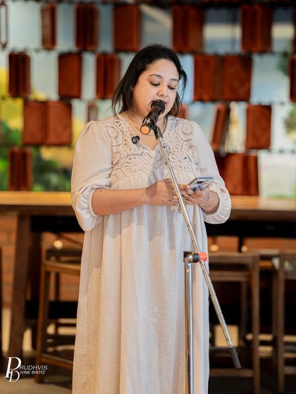 A poet reads from her phone during our "Second Chances" themed event. Her focused expression shows the deep connection she has with the words she's sharing.