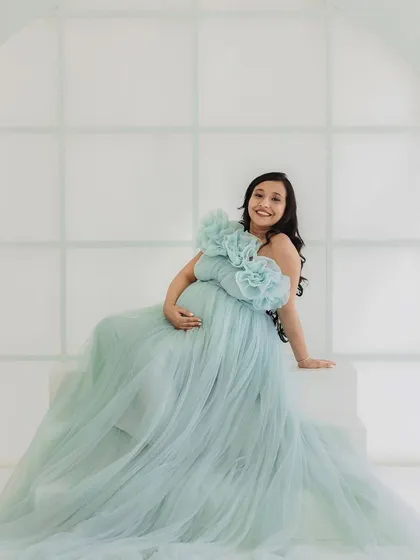 A happy and glowing mom-to-be. This shot showcases how the ice blue gown drapes beautifully even when seated, making it comfortable and gorgeous for a variety of poses.