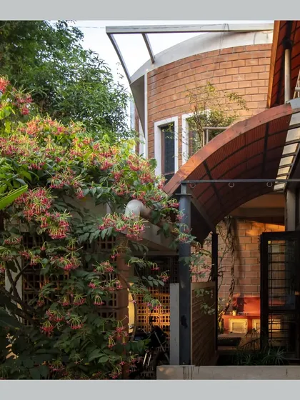 The exterior of the house is softened by a flowering creeper, showing how architecture and landscape can grow together.