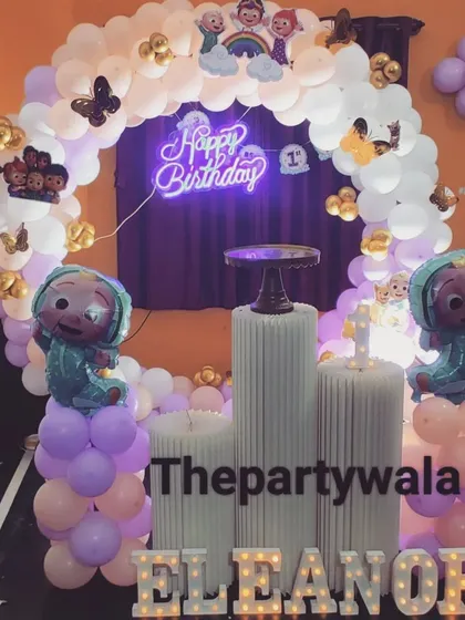 A cute Cocomelon ring decoration with pastel and white balloons. The light-up name and character foil balloons make it extra special.
