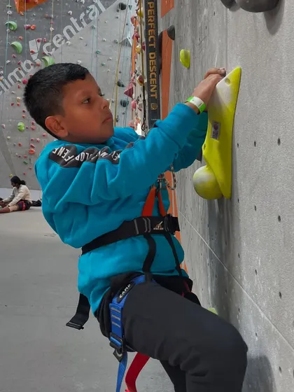 This young adventurer is carefully making his way up, showing great concentration. My kids' climbing parties are designed to be both fun and developmental.