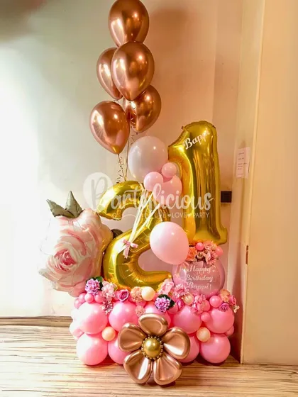 Turning 21 into a magical memory with this stunning rose gold and pink balloon arrangement, complete with floral accents.