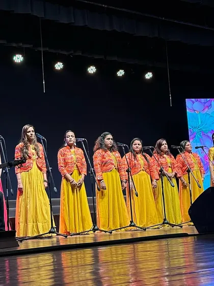 A wider shot of our teachers' choir on stage, dressed in beautiful coordinated outfits for the 'Jugalbandi' performance.