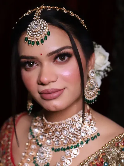 Another angle of the elegant royal bride, showing off the beautiful floral bun and the delicate 'sheesh patti'.
