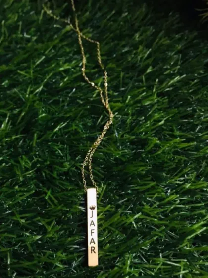 This elegant gold-plated bar necklace is personalized with an engraved name and a small crown, making it a beautiful and delicate gift.