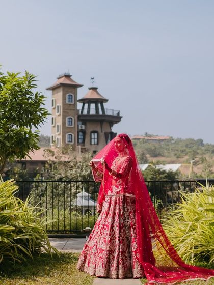 A dramatic shot of the bride with her long, flowing veil at a destination wedding. The makeup is bold enough to make a statement even from a distance.