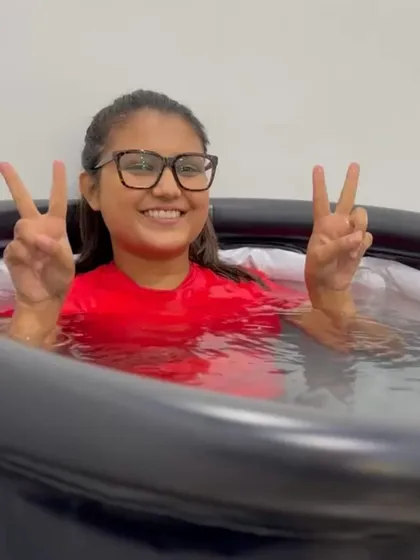 Peace, smiles, and ice. Another happy client enjoying the benefits of cold plunge therapy after her workout.