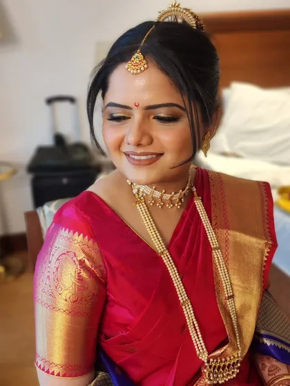 We kept the makeup simple, crisp, and elegant for this bride, allowing her traditional red and blue saree and pearl jewelry to take center stage.