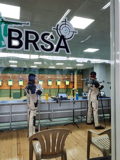 A view of the range through the glass partition, showing our competitive shooters in their gear during a serious practice session.