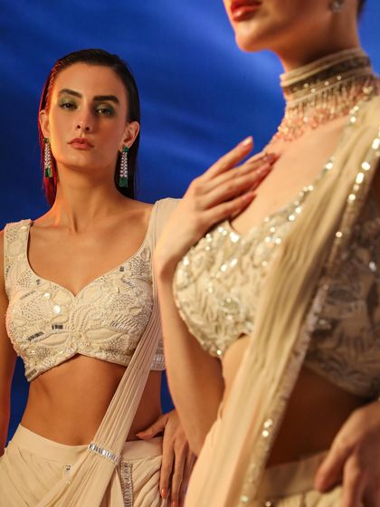 A dual-model shot featuring two different embellished blouses in a neutral palette. The composition creates a beautiful contrast and highlights the intricate details of each piece.