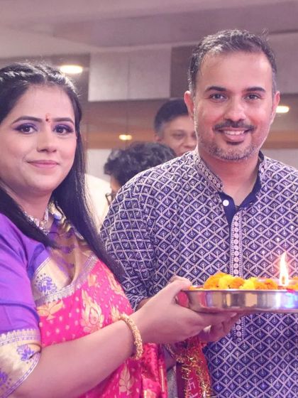 A couple participates in a traditional puja, holding a thali with flowers and a lit diya. We respectfully document the rituals and blessings of your family ceremonies.