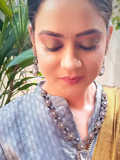 A tutorial-style image showing how to achieve a natural makeup look. This close-up focuses on the soft, earthy eyeshadow and groomed brows.