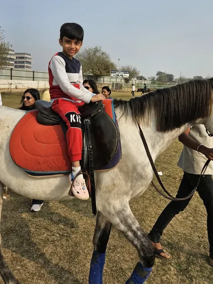 A young boy enjoys a led ride on our green lawns during a club event, looking like a natural in the saddle.
